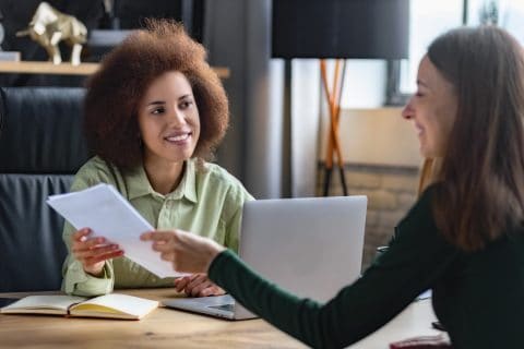 Caucasian female person having a job interview with a African American woman recruiter. Recruitment manager talking, hiring for job new employee sitting in office