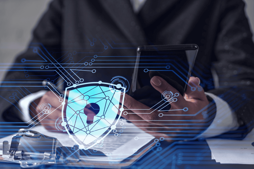 African American businesswoman in formal wear signing the contract to prevent probability of risks in cyber security. Checking the phone. Padlock Hologram icons over the working desk.